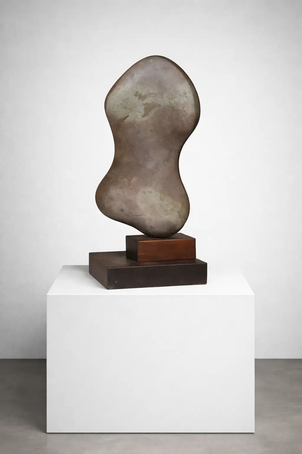 Female Torso by Javier Sauras, a vertical figurative stone sculpture on a solid wooden base. This 50x20 cm hand-carved stone artwork features a stylized human form with natural textures and a minimalist wooden pedestal. Torso femenino de Javier Sauras, una escultura vertical figurativa en piedra sobre una sólida base de madera. Esta obra de arte tallada a mano, de 50 x 20 cm, presenta una figura humana estilizada con texturas naturales y un pedestal minimalista de madera.