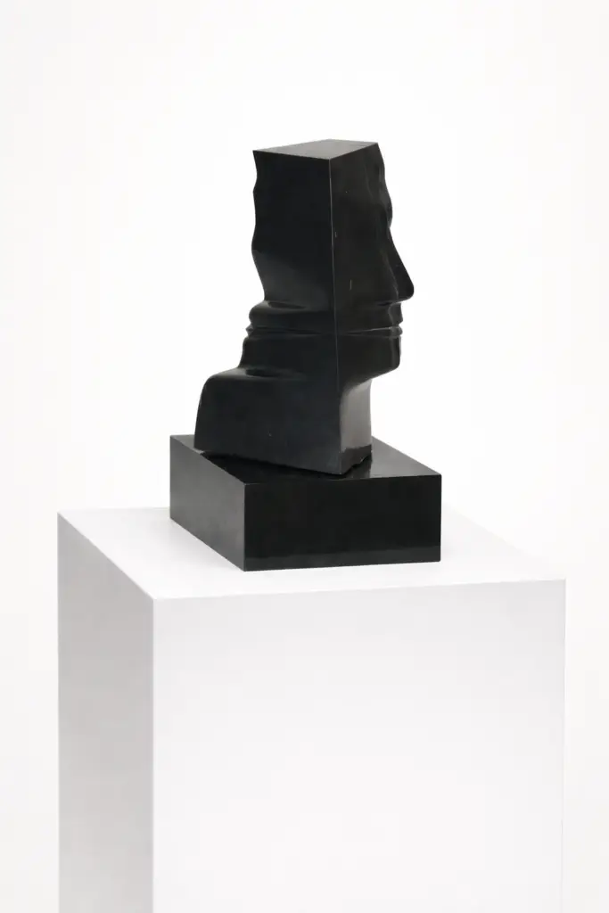 Perfles by Joaquín González Blázquez, a vertical contemporary marble sculpture on a solid wooden base. This 50x26 cm hand-carved stone artwork features a smooth, refined finish with organic vertical lines on a minimalist pedestal. Perfles, de Joaquín González Blázquez, es una escultura vertical contemporánea de mármol sobre una sólida base de madera. Esta obra de arte en piedra, tallada a mano en 50 x 26 cm, presenta un acabado liso y refinado con líneas verticales orgánicas sobre un pedestal minimalista.