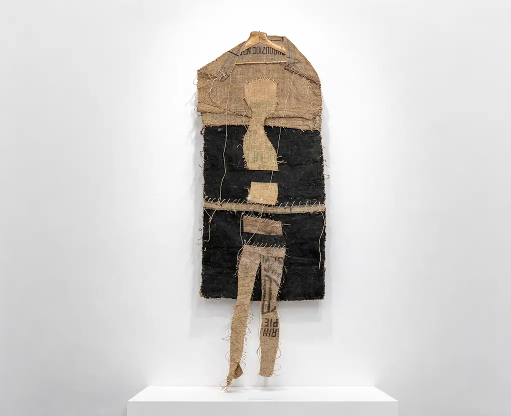 Home infinit, formes pallareses by Joaquim Pujol Grau, a large-scale vertical mixed-media artwork made of burlap, acrylic, and twine. This 175x161 cm contemporary textile piece features raw, expressive textures and organic fiber elements with a neutral, earthy color palette. Home infinit, formes pallareses de Joaquim Pujol Grau, una obra de arte vertical de técnica mixta a gran escala realizada con arpillera, acrílico y cordel. Esta pieza textil contemporánea de 175 x 161 cm presenta texturas crudas y expresivas, elementos de fibra orgánica y una paleta de colores neutros y terrosos.