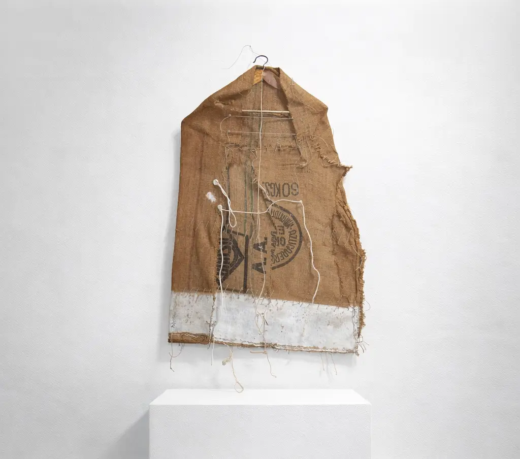 Pallarese Forms (Artwork ID 147) by Joaquim Pujol Grau, a vertical mixed-media textile sculpture made of burlap, acrylic, and twine. This 110x75 cm contemporary artwork features layered, raw fiber textures and a monochromatic, organic composition. Pallarese Forms (Obra ID 147) de Joaquim Pujol Grau, una escultura textil vertical de técnica mixta realizada con arpillera, acrílico y cordel. Esta obra contemporánea de 110 x 75 cm presenta texturas de fibras crudas superpuestas y una composición orgánica monocromática.