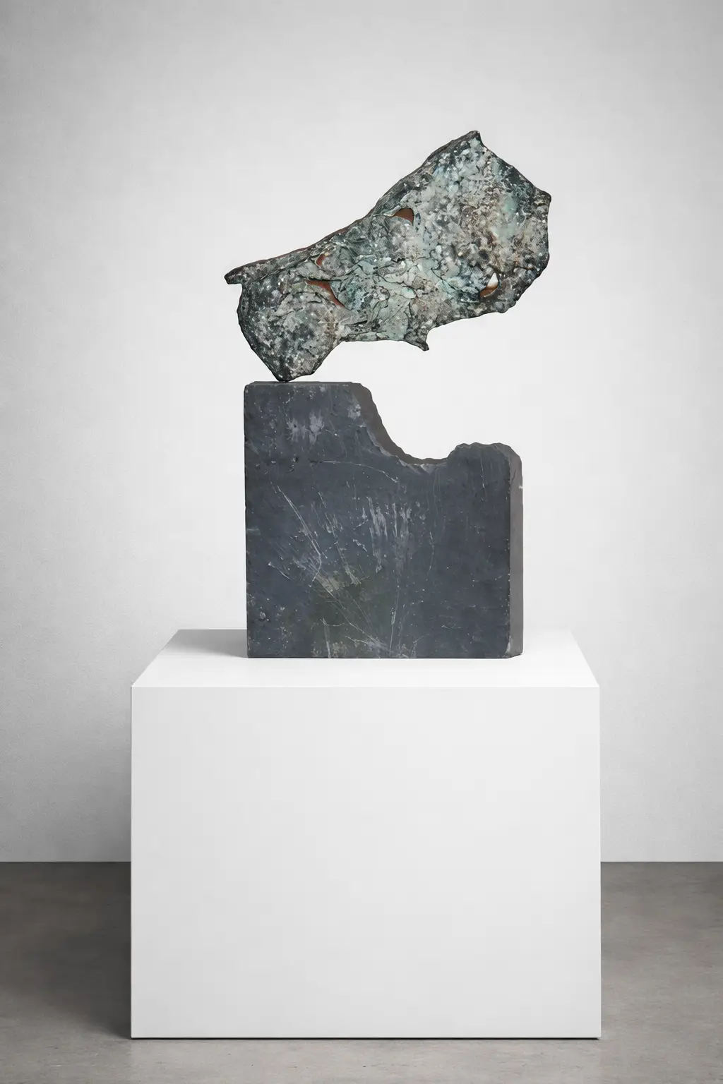 A vertical cast bronze sculpture titled "Bull’s Hide" by Casto Solano, featuring a textured, organic form mounted on a dark slate base. The bronze has a weathered, metallic finish with intricate surface details. Escultura vertical de bronce fundido titulada "Piel de toro", de Casto Solano, que presenta una forma orgánica y texturizada montada sobre una base de pizarra oscura. El bronce tiene un acabado metálico envejecido con intrincados detalles en la superficie.
