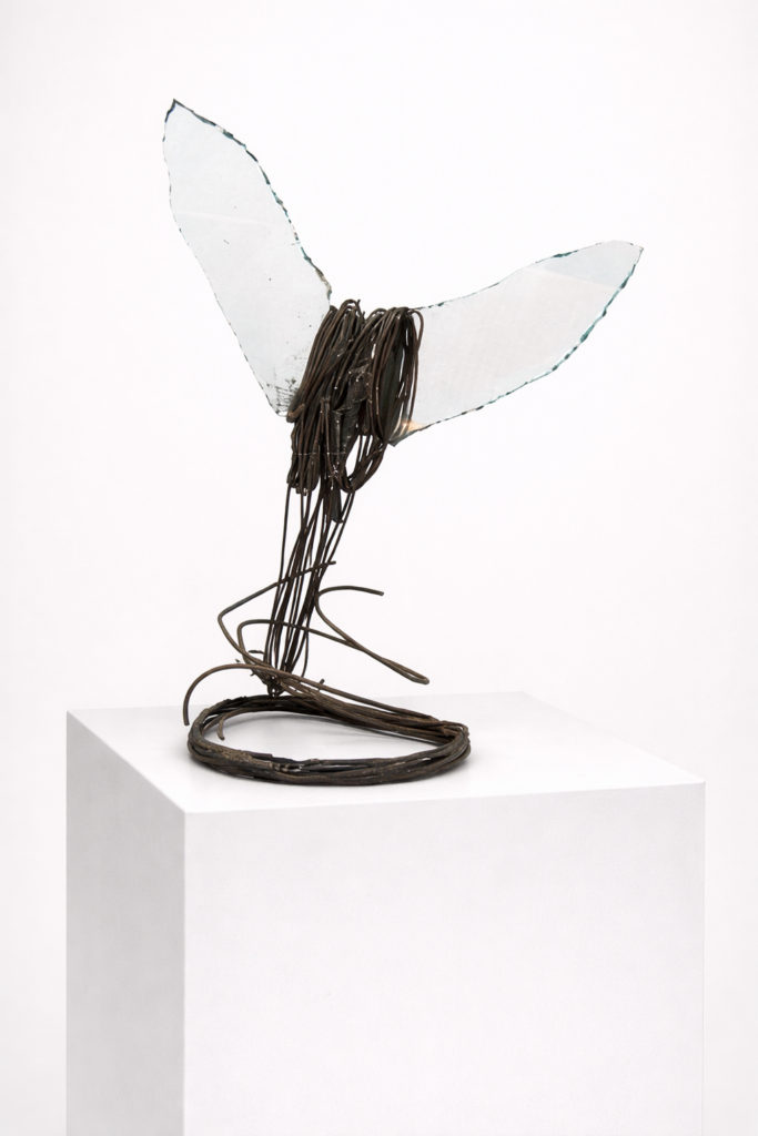 Ícaro caído (Fallen Icarus) (Artwork ID 028bis) by José Carlos Balanza, a vertical contemporary sculpture made of iron and glass. Measuring 85x50 cm, this mixed-media artwork explores themes of fragility and strength, featuring industrial metallic textures paired with translucent glass elements. Ícaro caído (Referencia 028bis) de José Carlos Balanza, una escultura vertical contemporánea realizada en hierro y vidrio. Con unas dimensiones de 85x50 cm, esta obra de técnica mixta explora temas de fragilidad y resistencia, combinando texturas metálicas industriales con elementos de vidrio traslúcido.